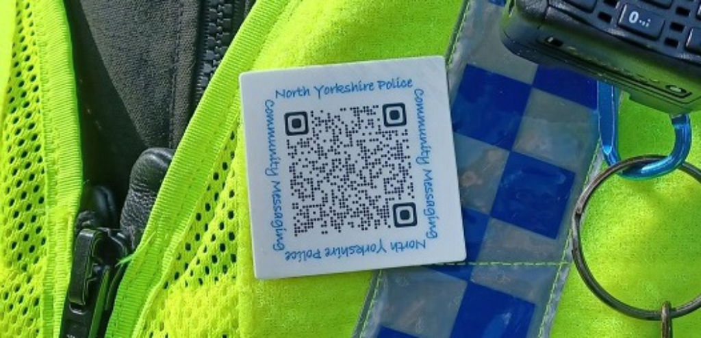 Police officer wearing a QR code badge for North Yorkshire community messaging