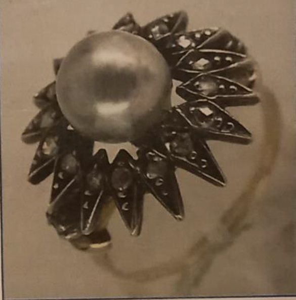 gold ring with large pearl in the centre surrounded by diamonds 