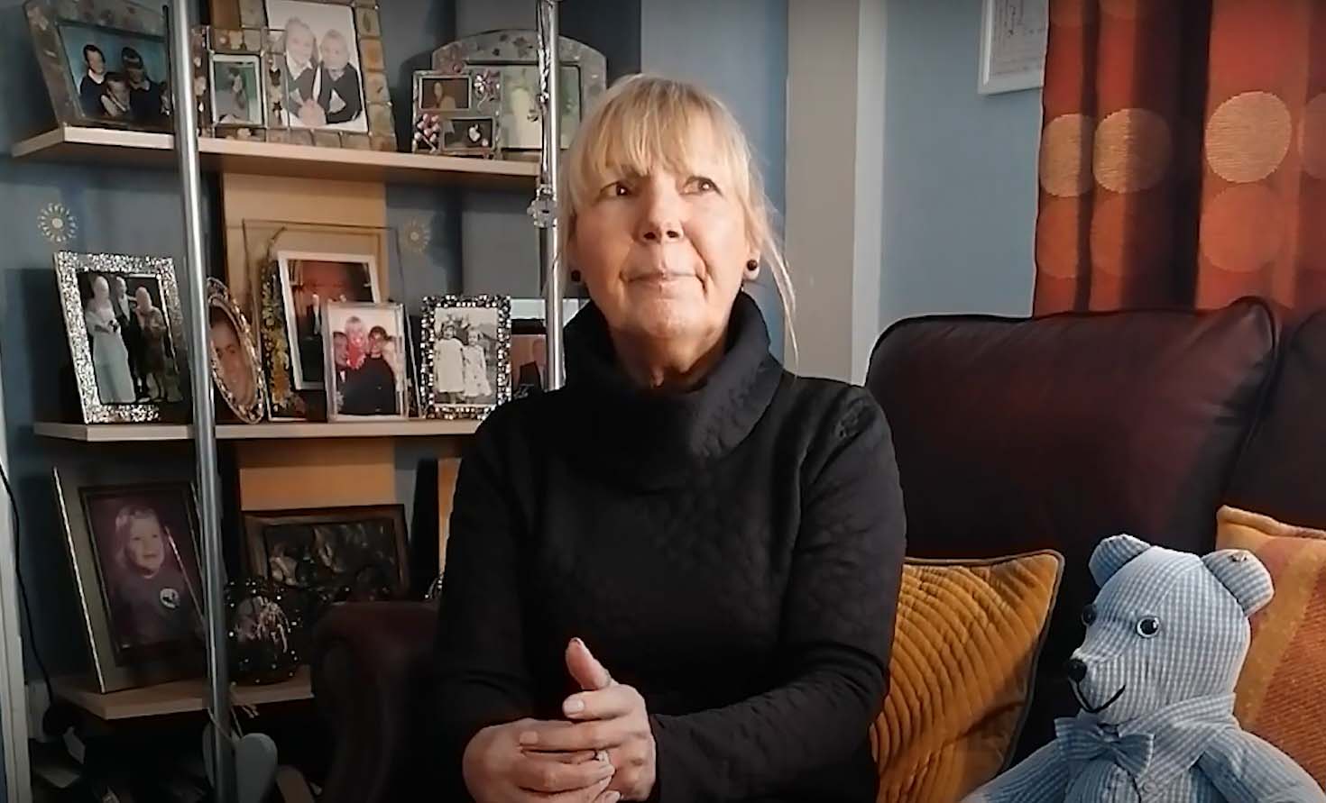A woman with blonde hair sits on a sofa 