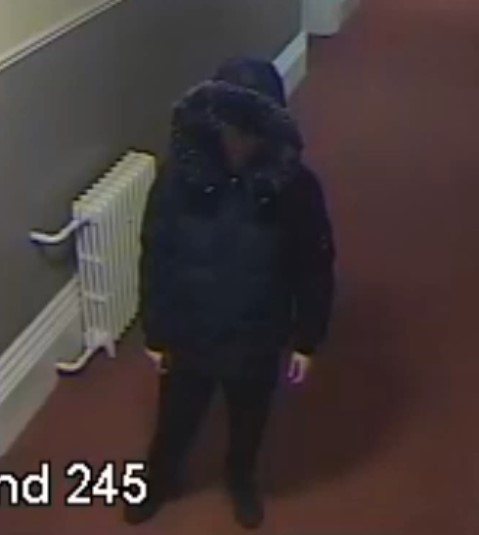CCTV image of man in black padded coat with hood