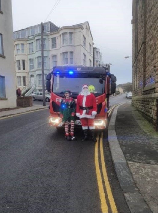 Santa getting a ride on a fire engine