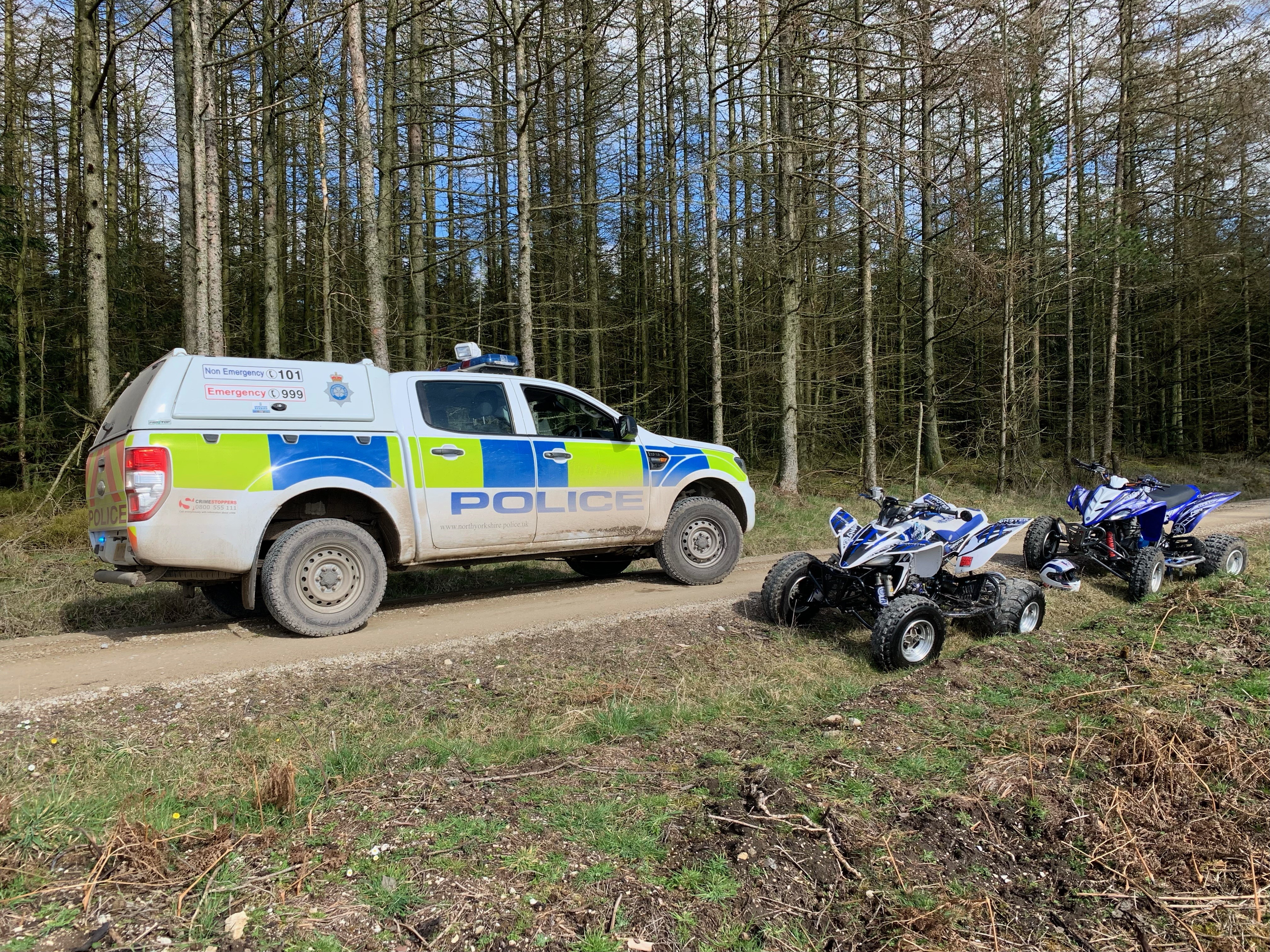 police car checking off-road vehicles in forest 