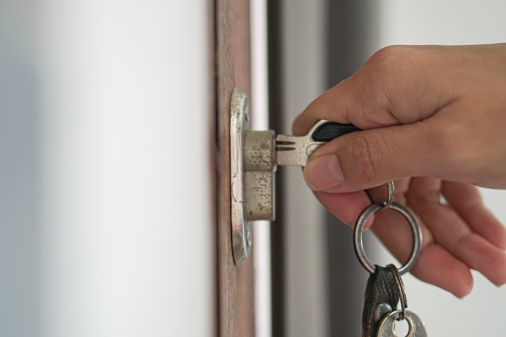 a person putting a key in a door lock