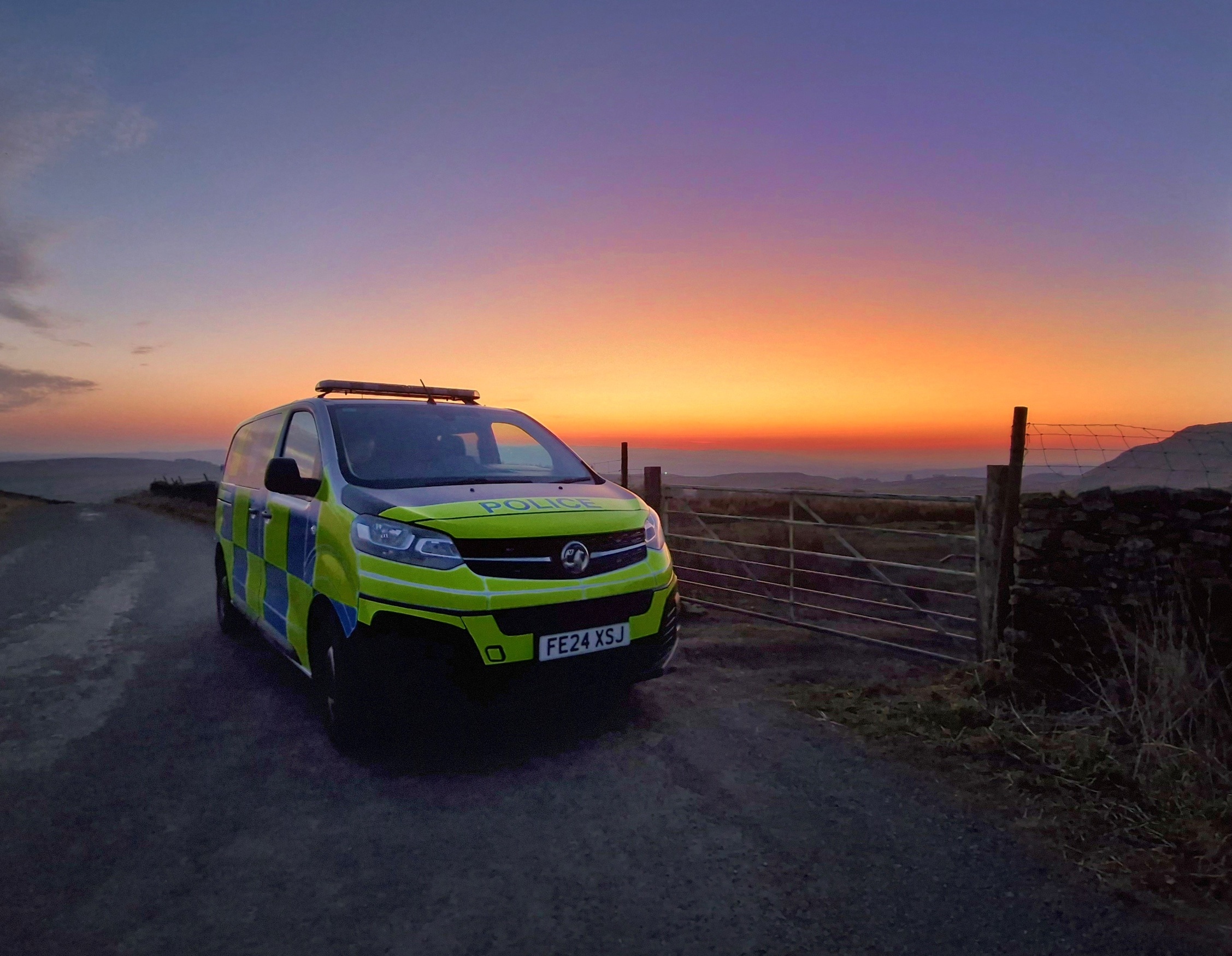 police van with sunset behind it