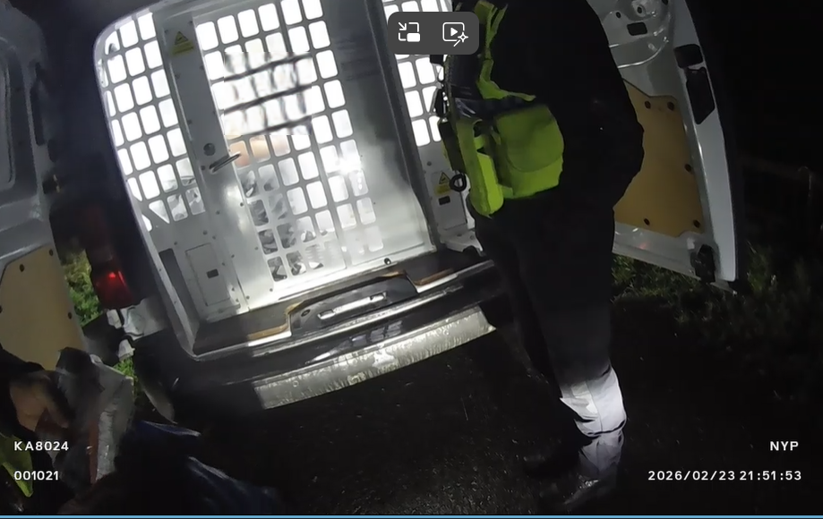 back of cell van and uniformed police officer 